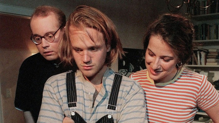 Philipp (Philipp Neubauer, li), Klaus (Moritz A. Sachs) und Dani (Clelia Sarto) öffnen den roten Koffer und erleben eine Überaschung.