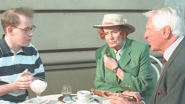 Priesnitz (Carlos Werner, rechts) und Amélie (Anna Teluren) sind von Philipps (Philipp Neubauer) Idee begeistert.