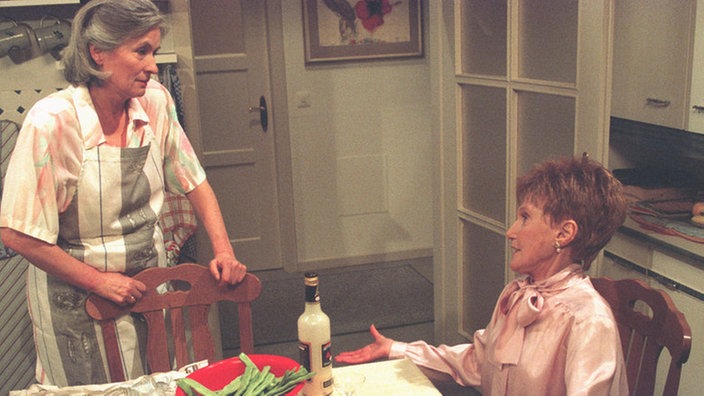 Rosi (Margret van Munster) ist ganz aufgeregt: Heute ist Pastor Traube zu Besuch, den sie doch so verehrt. Sie weist Wanda (Maria Wachowiak-Holonbeck) in ihre Schranken.