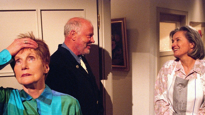 Rosi (Margret van Munster, li) hat sich verplappert und verraten, dass Wanda (Maria Wachowiak) doch in der Wohnung ist. Herrn Traube (Jost Siedhoff) kommt dies sehr gelegen.