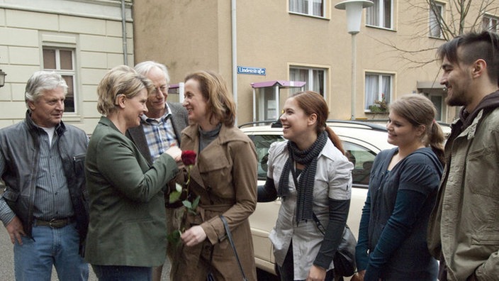 Rückkehr in die Lindenstraße: Anna kommt in den offenen Vollzug und kann somit stundenweise wieder in ihrer gewohnten Umgebung sein (v.l. Jo Bolling, Andrea Spatzek, Joachim Hermann Luger, Irene Fischer, Julia Stark, Dominique Kusche, Johannes Scheit).