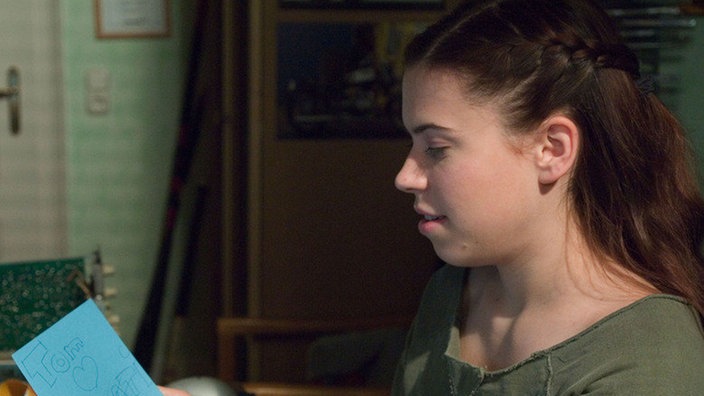 Sarah (Julia Stark) entdeckt Liebesbotschaften von Tom an Kathy und begreift, warum ihr Bruder in letzter Zeit so durcheinander ist.
