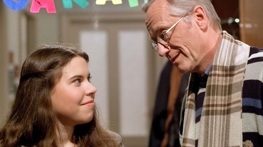 Sarah (Julia Stark) hat ihre stationäre Behandlung beendet und kehrt nach Hause zurück. Dort wird sie von Hans (Joachim Hermann Luger) begrüßt.