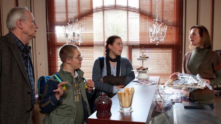 Sarah (Julia Stark) verkündet Hans (Joachim Hermann Luger, links), Anna (Irene Fischer, rechts) und Martin (Jan Grünig), dass sie vor hat, in eine WG zu ziehen