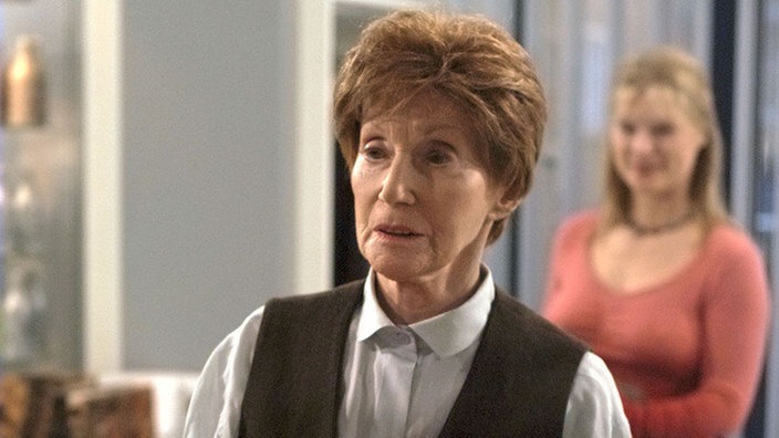 Seit ihrem Sturz benötigt Rosi (Margret van Munster) auch beim Friseur (Sybille Waury, rechts) eine besondere Sitzhilfe.