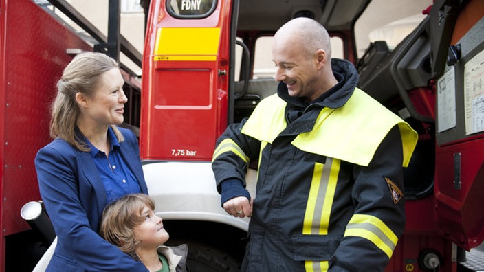 Tanja, Simon und Chris stehen vor einem Feuerwehrauto