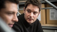 Timo und Enzo unterhalten sich in der Werkstatt