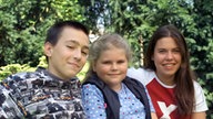 Tom, Sophie und Sarah sitzen auf einer Bank