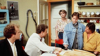Valerie (Nadine Spruß) wird im Beisein von Otto Pichelsteiner (Werner Possardt, links), Andy (Jo Bolling, rechts) und Gabi (Andrea Spatzek, Mitte) vom Staatsanwalt (Axel Siefen) verhört.