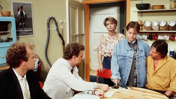 Valerie (Nadine Spruß) wird im Beisein von Otto Pichelsteiner (Werner Possardt, links), Andy (Jo Bolling, rechts) und Gabi (Andrea Spatzek, Mitte) vom Staatsanwalt (Axel Siefen) verhört.