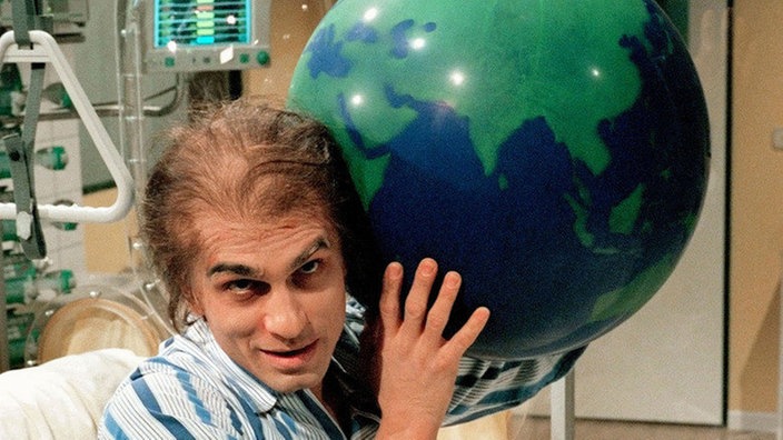Vasily (Hermes Hodolides) auf dem Weg der Besserung versucht sich als Atlas.