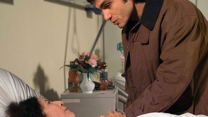 Vasily (Hermes Hodolides) besucht seine kranke Mutter Elena (Domna Adamopoulou). Sie fehlt im “Akropolis” an allen Ecken und Enden.