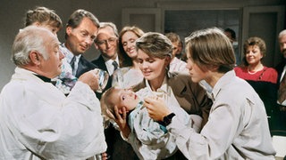 Viele Verwandte, Nachbarn und Freunde haben sich zur Taufe von Hans' und Annas Kindern eingefunden (v.l.: Eckehard Koch, Thomas Frey, Joachim Hermann Luger, Irene Fischer, Andrea Spatzek, Moritz A. Sachs, Marie-Luise Marjan, Bill Mockridge).