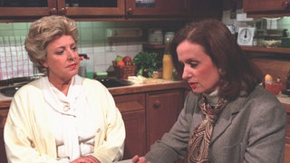 Zerknirscht bittet Anna (Irene Fische, rechts) Helga (Marie-Luise Marjan) um Hilfe.
