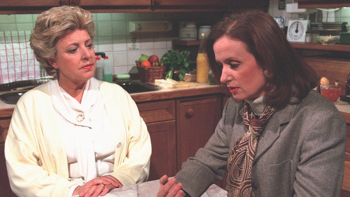 Zerknirscht bittet Anna (Irene Fische, rechts) Helga (Marie-Luise Marjan) um Hilfe.