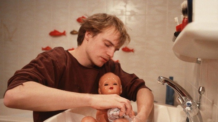 Zorro (Thorsten Nindel) übt mit einer Puppe das Baden und Wickeln.