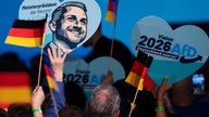 Das Bild zeigt Deutschlandflaggen und Herzen mit AfD drauf.