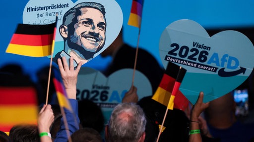 Das Bild zeigt Deutschlandflaggen und Herzen mit AfD drauf.