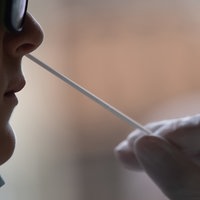 Nasenabstrich bei einer Maske tragenden Person