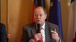Peer Steinbrück im Portrait, mit Mikrofon in der Hand