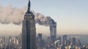 Die Zwillingstürme des World Trade Centers brennen hinter dem Empire State Building (11.09.2001)