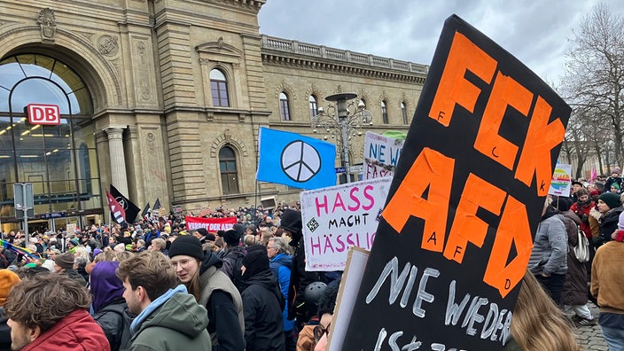Demonstranten stehen mit Plakaten vor dem Magdeburger Hauptbahnhof bei einer Demonstration gegen rechts (04.02.2024).