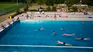 Badegäste schwimmen im Rheinbad in Düsseldorf