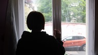 Jugendliche steht am Fenster