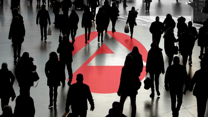Das Logo der Agentur für Arbeit inmitten einer anonymen Menschenmenge