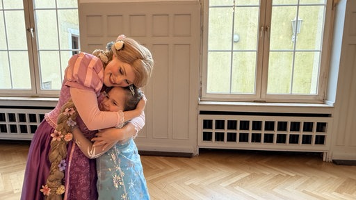 Jolene Weber, verkleidet als "Rapunzel", umarmt ein kleines Mädchen.