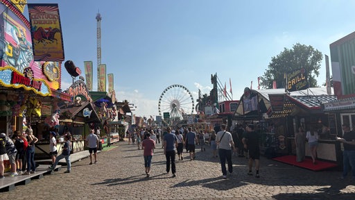 Gäste schlendern zwischen den Ständen der Düsseldorfer Rheinkirmes