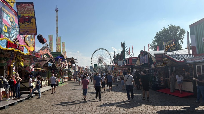 Gäste schlendern zwischen den Ständen der Düsseldorfer Rheinkirmes