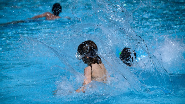 Kinder springen im Sommerbad Neukölln ins Schwimmbecken. 