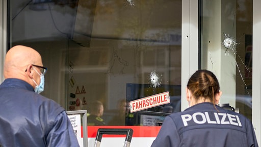 In der Scheibe einer Fahrschule sind mehrere Einschusslöcher zu sehen