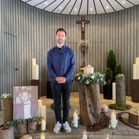 Daniel Aßmann steht in einer Kapelle. Alles um ihn herum ist so dekoriert, als wäre er Gast seiner eigenen Bestattung.