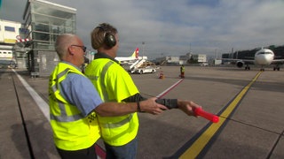 "Der geschenkte Tag"-Kandidat winkt ein Flugzeug ein