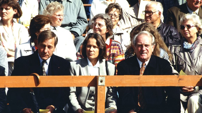 Johannes Rau, seine Ehefrau Christina Rau und Wolfgang Clement auf einer Tribüne