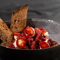 „Das perfekte Tatar“ von der Rinderhüfte, Schalotten-Gewürzgurken-Chutney, eingelegte Chili, Röstbrot