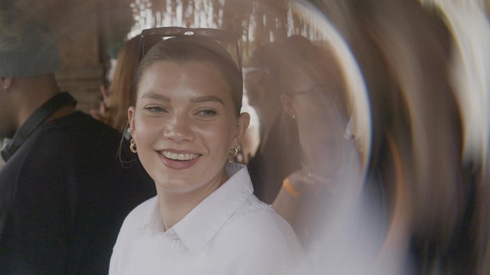 Porträt von Chanel, im Hintergrund sind andere Menschen verschwommen zu sehen 