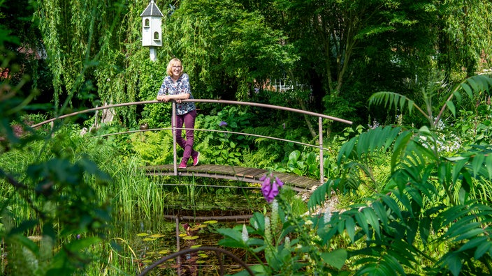 Hildegard Rave auf einer Brücke, die über einen Teich führt.