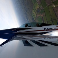 Nahaufnahme: Ein Sportflugzeug macht einen Looping.