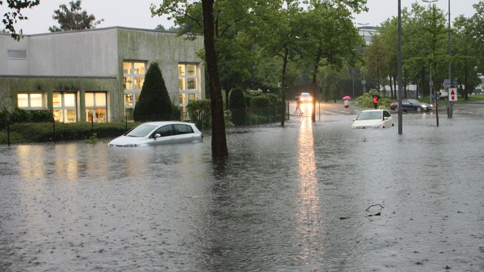 Autos stehen am 28.07.2014 auf einer überfluteten Straße in Münster. 