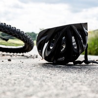 Fahrradhelm und Fahrrad liegen auf der Straße, Symbolbild