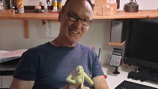 Figurenmacher Lutz Wunder und eine seiner Ehrwin-Figuren im Atelier