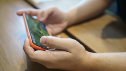 Person spielt Mobile-Games auf dem Smartphone.