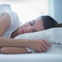 Eine Frau liegt im Bett und schläft entspannt