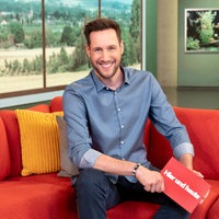 Sven Kroll sitzt im Hier und heute Studio auf dem roten Studio-Sofa und lächelt in die Kamera.