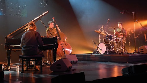 Pianist Fergus McCreadie mit Bassist und Schlagzeuger auf der Bühne.