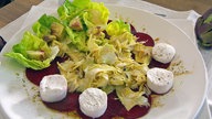 Teller mit Artischocken auf roter Bete mit Ziegenfrischkäse