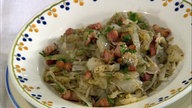Weißkohl mit Kartoffeln und Speck in einem Teller angerichtet